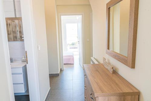 a bathroom with a wooden table and a mirror at Modern, Cheerful & Dream Catching Villa in Corinth in Isthmia