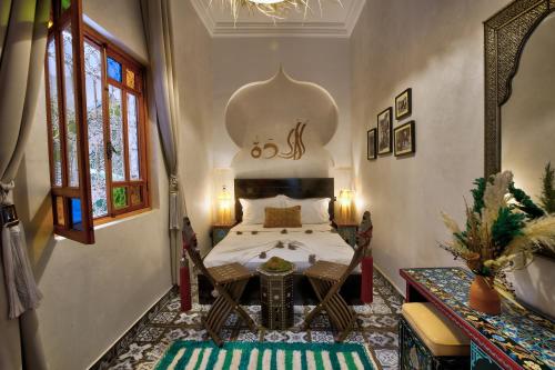 a bedroom with a bed and a table in a room at Riad Arabkech in Marrakesh
