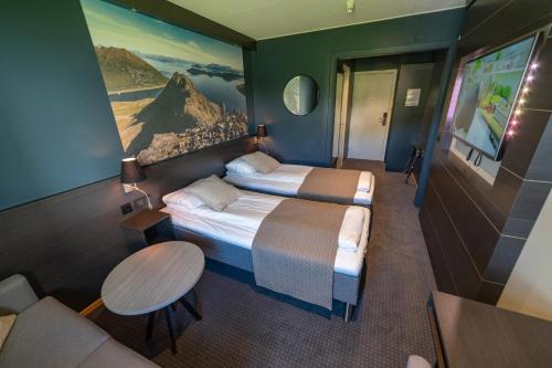a hotel room with two beds and a couch at Hotell Maritim Skjervoy in Skjervøy