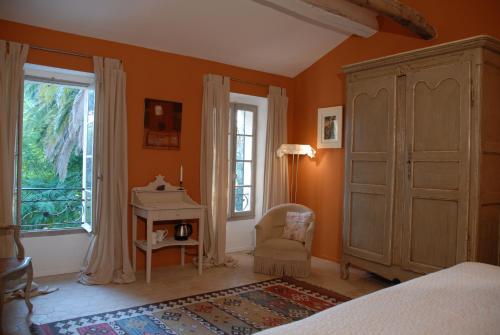 une chambre avec un lit, un bureau et une fenêtre dans l'établissement La Maison, à Bormes-les-Mimosas