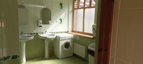 y baño con 2 lavabos y lavadora. en Kempings Sniedzes, en Ķegums