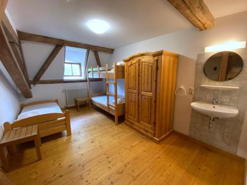 a bedroom with a bunk bed and a sink at Zentrum für Umwelt und Kultur - Gästehaus und Jugendbildungseinrichtung im Maierhof in Benediktbeuern