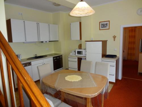 a kitchen with a table and white cabinets at Ferienhaus Lohberg in Lohberg