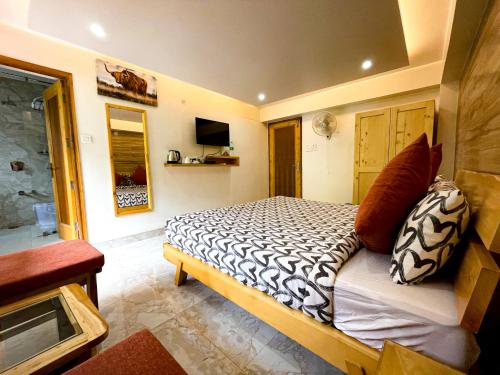a bedroom with a bed with pillows on it at The Wild Yak in Mandi
