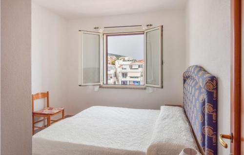 een slaapkamer met een bed en een raam bij Cozy Apartment In La Ciaccia With Kitchen in Codaruina