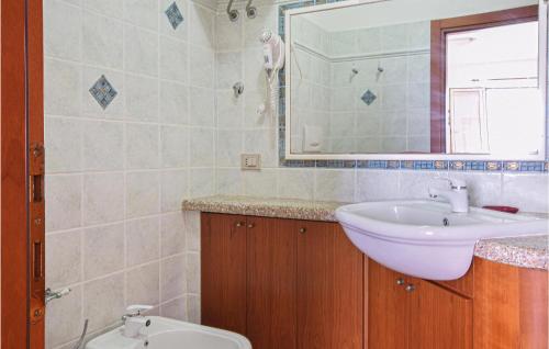 een badkamer met een wastafel, een toilet en een spiegel bij Cozy Apartment In La Ciaccia With Kitchen in Codaruina