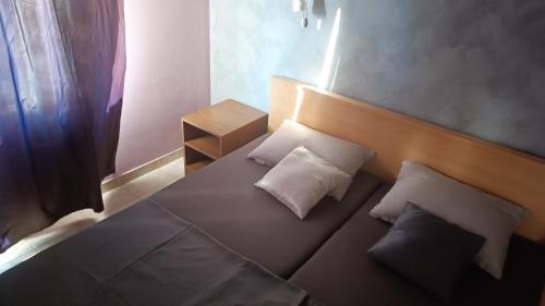 un letto con due cuscini sopra in una stanza di Apartments Niko a Trogir