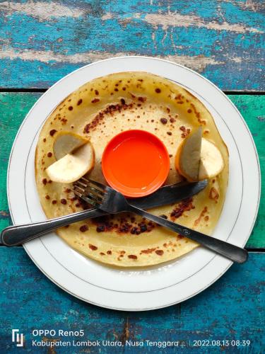 a plate of food with a cup and utensils on at H.Said Homestay in Gili Trawangan