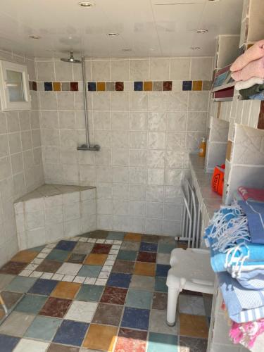 ein Bad mit Fliesenboden und Dusche in der Unterkunft Les Olivades in Vauvert