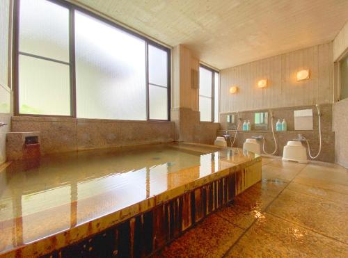 a large room with a pool of water in a bathroom at Sessokyo Onsen Hall in Ōma