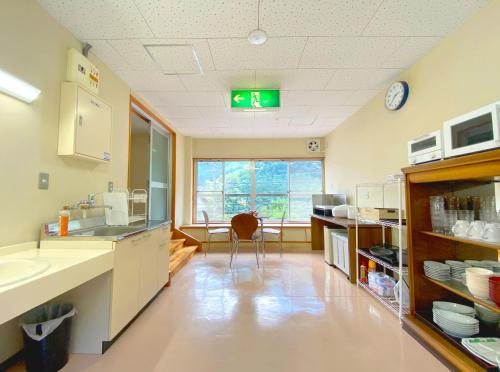 a room with a kitchen with a clock on the ceiling at Sessokyo Onsen Hall in Ōma