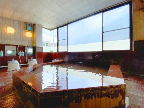 a large pool of water in a room with a large window at Sessokyo Onsen Hall in Ōma