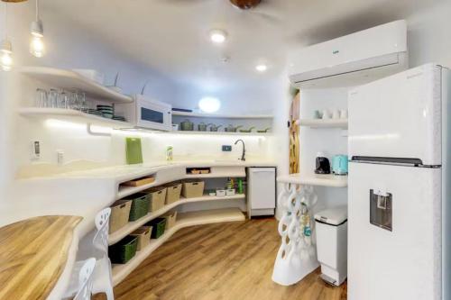a kitchen with white cabinets and a refrigerator at Alterhome Swan villas with swimming pool and ocean views in Placencia Village