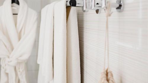 un grupo de toallas blancas colgando de un estante en el baño en Hotel Indigo Madrid - Princesa, an IHG Hotel, en Madrid