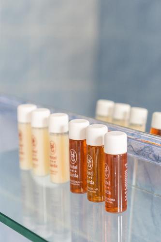 a row of bottles of honey on a glass shelf at Hotel Garda in Milan
