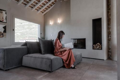 a woman sitting on a couch with a laptop at Locanda MaMaGiò in Valdobbiadene