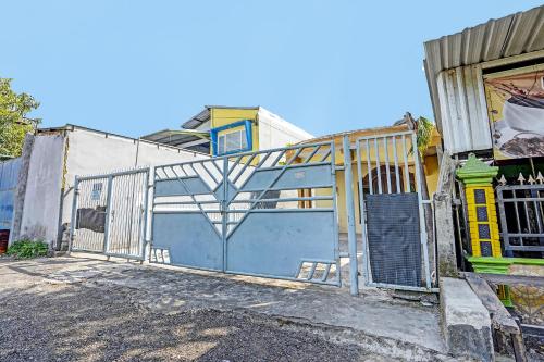 un edificio con cancello e garage blu di OYO 3285 Wonoayu Residence Syariah a Sidoarjo