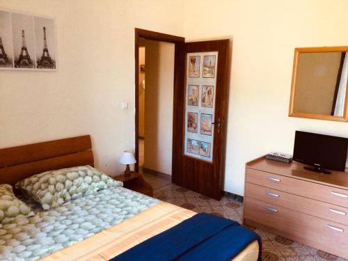 1 dormitorio con 1 cama, vestidor y TV en Natura Bella appartamento en Montoro Inferiore