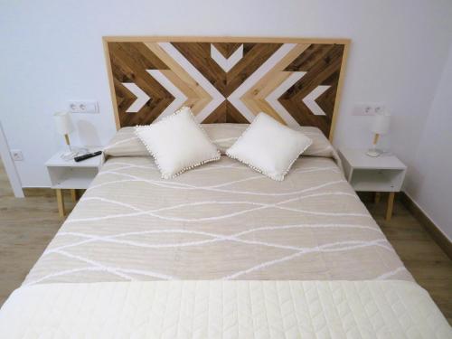 a bedroom with a large bed with two white pillows at Apartamento Casa Roda in Bielsa