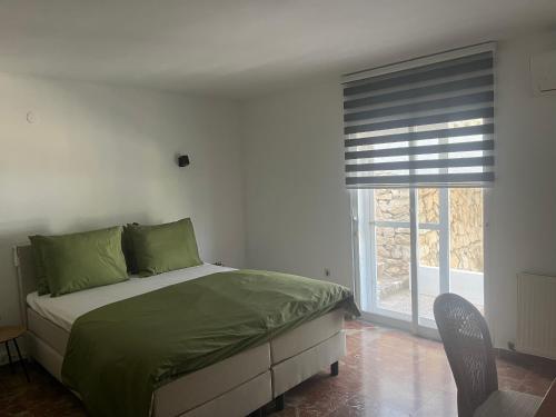 een slaapkamer met een bed met groene lakens en een raam bij Casa Biamar in Calpe