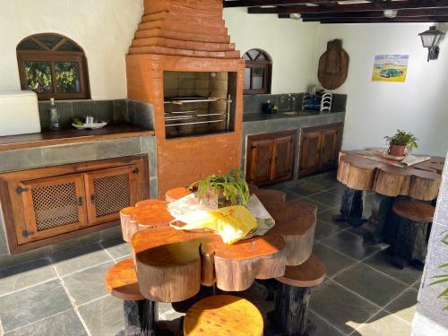 una cocina con una mesa con taburetes de madera. en Casa encantadora na serra-Teresópolis en Teresópolis