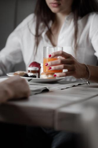 a woman sitting at a table with a glass of juice at Locanda MaMaGiò in Valdobbiadene