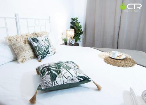 ein weißes Bett mit einem Kissen und einem Tablett darauf in der Unterkunft LARGE COMPLETE APARTMENT, In The Center With Balcony in Santiago de Compostela