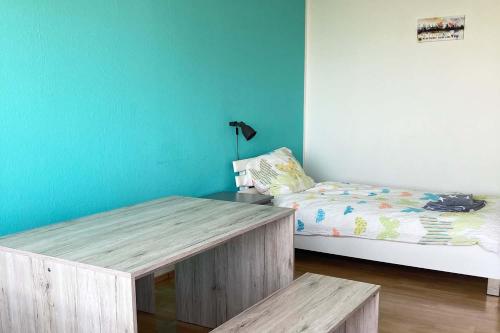 ケルンにあるApartment Deutzのベッド、木製テーブル、ベンチが備わる客室です。