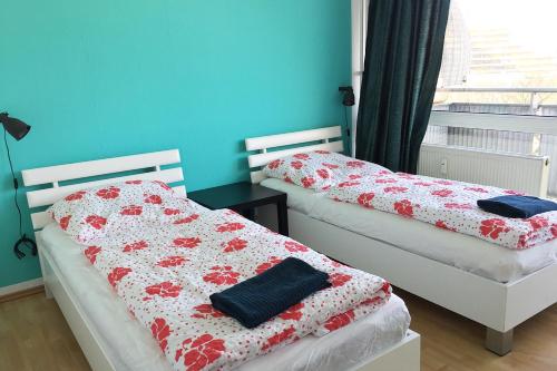 2 łóżka pojedyncze w pokoju z niebieskimi ścianami w obiekcie Apartment Deutz w Kolonii