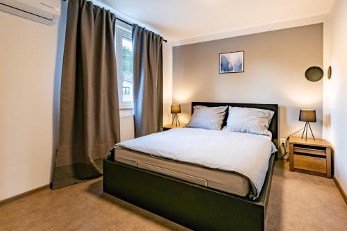 a bedroom with a bed and a window at bergRESORT apartments in Děčín