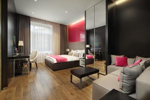 a hotel room with a bed and a couch at Maccani Black Luxury Suites in Belgrade