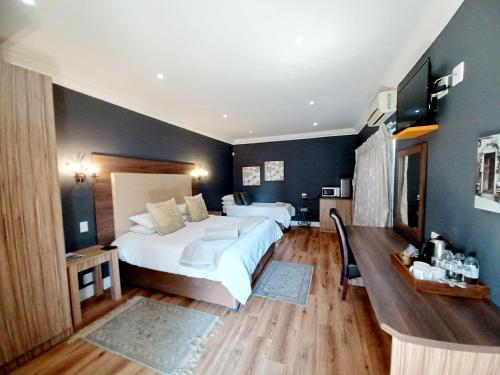 a bedroom with a large white bed and blue walls at Casa Cara Guest House in Parys