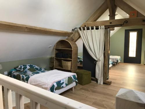 ein Schlafzimmer mit einem Bett und einem Kinderbett in einem Zimmer in der Unterkunft Gîte de la Kélidoine in Montigny-sur-Armançon