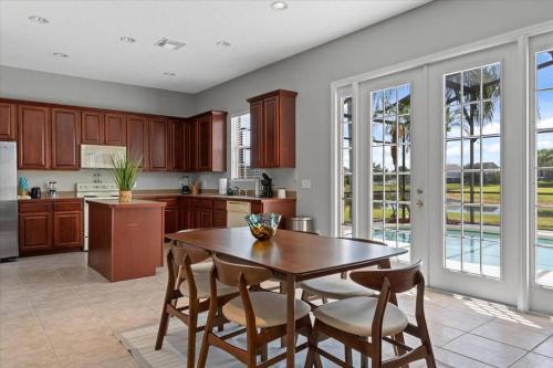 a kitchen with a wooden table and some chairs at LONG STAYS! Lakefront - Gated Pool Home in Orlando