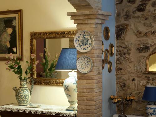 a room with a table with a lamp and a mirror at Kimera in Piazza Armerina