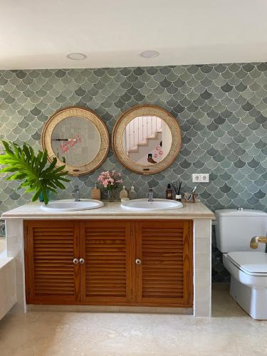 a bathroom with two sinks and two mirrors at Villa Cana in San Roque