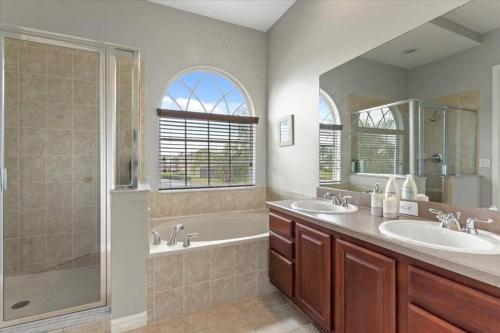 a bathroom with two sinks and a tub and a shower at LONG STAYS! Lakefront - Gated Pool Home in Orlando