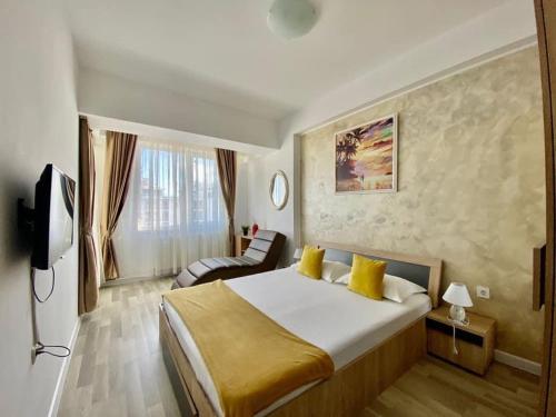 a hotel room with a large bed and a chair at Maria Summer Apartaments in Mamaia