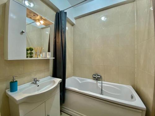 een badkamer met een wastafel, een bad en een wastafel bij Maria Summer Apartaments in Mamaia