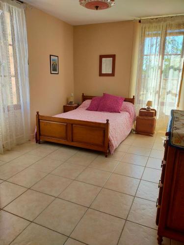 une chambre avec un lit avec des oreillers roses dessus dans l'établissement Gite Au Tranquillou, à Albias