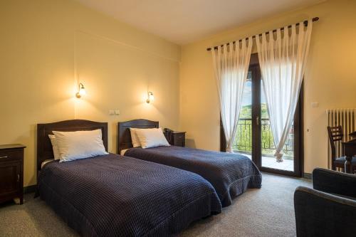 - une chambre avec 2 lits et une grande fenêtre dans l'établissement Guesthouse Anastasia, à Nestórion