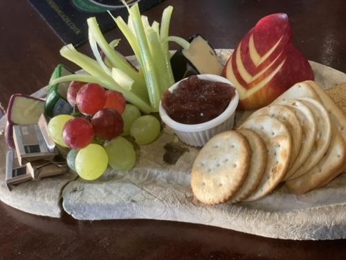 a plate of food with cheese and grapes and dips at The Lilly Restaurant With Rooms in Llandudno