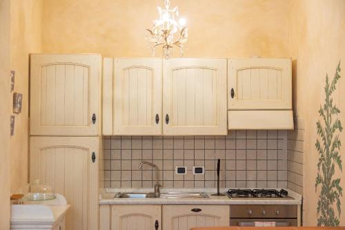 a kitchen with white cabinets and a sink at Palazzo Ghibellina by Rental in Florence in Florence