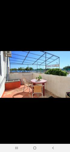 a patio with a table and chairs on a balcony at Basil Apartments and Rooms in Betina
