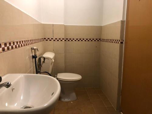 a bathroom with a white toilet and a sink at Rumah Tepi Istana in Kuala Terengganu