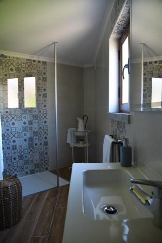 a bathroom with a sink and a shower at Casa do Alfaiate in Chãos