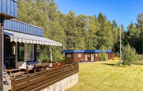 a house with a deck with a table and benches at 2 Bedroom Nice Home In Timmersdala in Götene