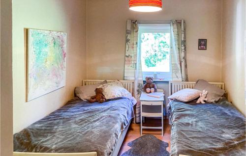twee bedden in een kamer met twee teddyberen erop bij 2 Bedroom Nice Home In Timmersdala in Götene