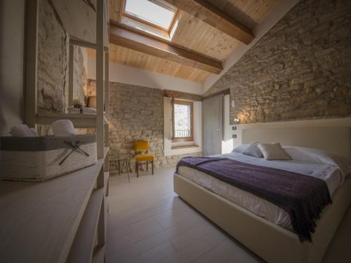 a bedroom with a bed and a stone wall at Brisighella Green Wellness in Brisighella