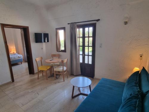 ein Wohnzimmer mit einem blauen Sofa und einem Tisch in der Unterkunft Arhodiko Hotel in Ammoudara